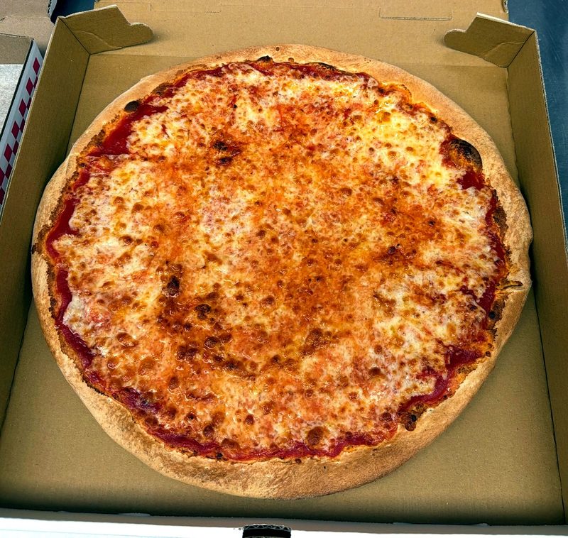 Cheese pizza photographed from above in a takeout box