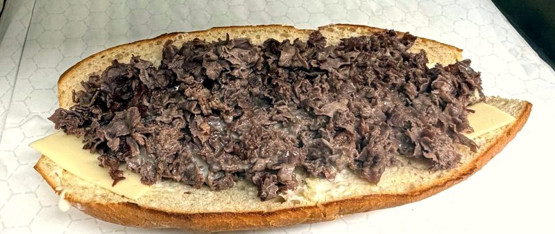 Chopped steak and cheese on a long sandwich roll